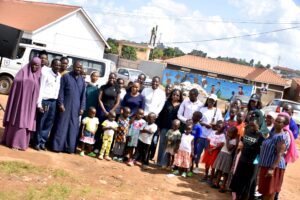 Some of the inter-faith youth take a photo with the community members after raising awareness on disease control in Kampala City.